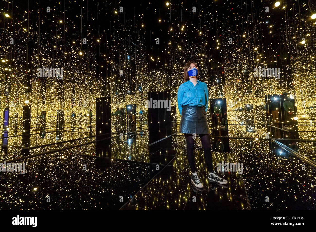 London, UK.  17 May 2021.A Tate staff member views 'Infinity Mirrored Room – Filled with the Brilliance of Life', 2011, by Yayoi Kusama.  Preview of Yayoi Kusama: Infinity Mirror Rooms on show at Tate Modern, in partnership with Bank of America with additional support from UNIQLO, from 18 May to 12 June 2022.  Credit: Stephen Chung / Alamy Live News Stock Photo