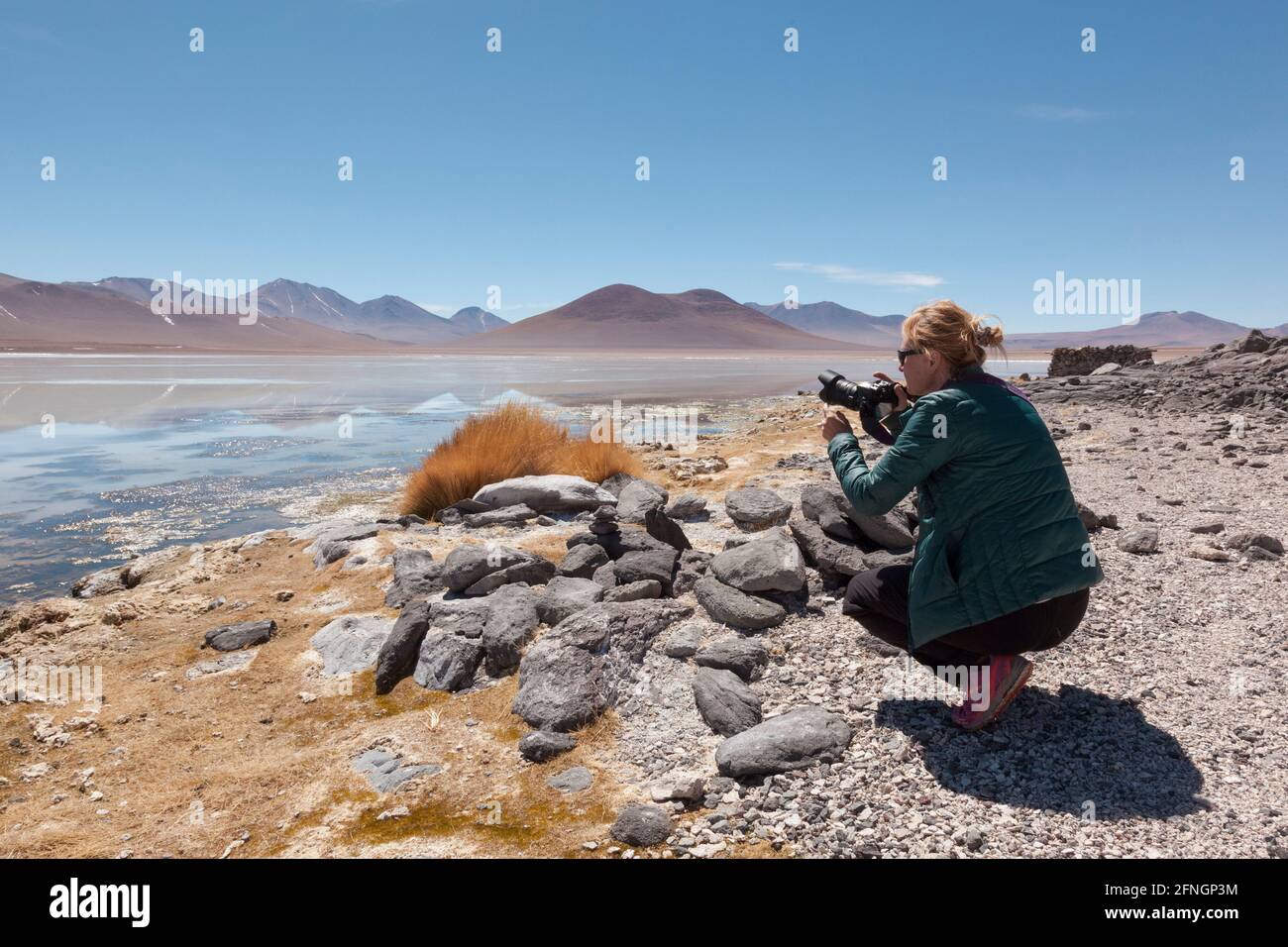 A tourist takes photographs at the Laguna Verde, Bolivia Stock Photo