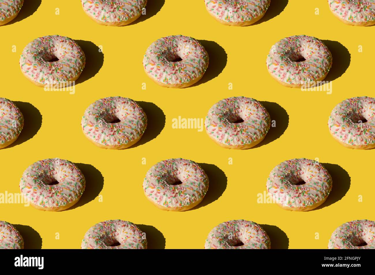 Donut pattern on yellow background. Sunlight minimal trendy concept Stock Photo