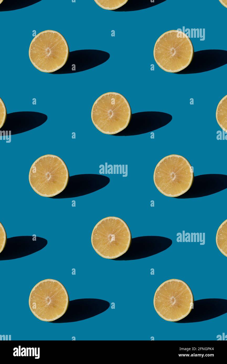 Grapefruit pattern on a blue background. Minimal concept with hard light shadows. Stock Photo