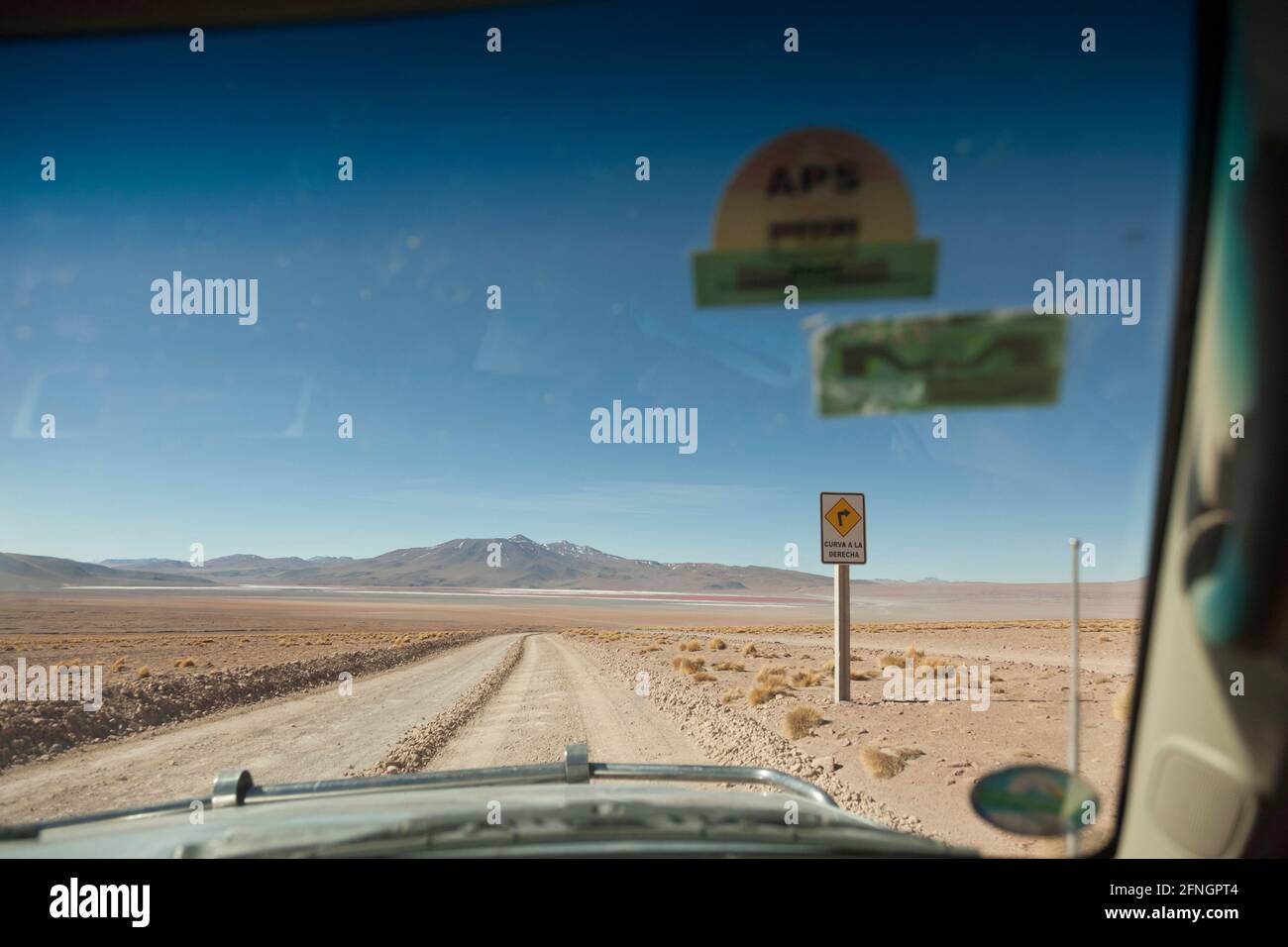 Viewed from the front passenger seat, a 4x4 vehicle drives along a Bolivian desert track on an overland tourist safari Stock Photo