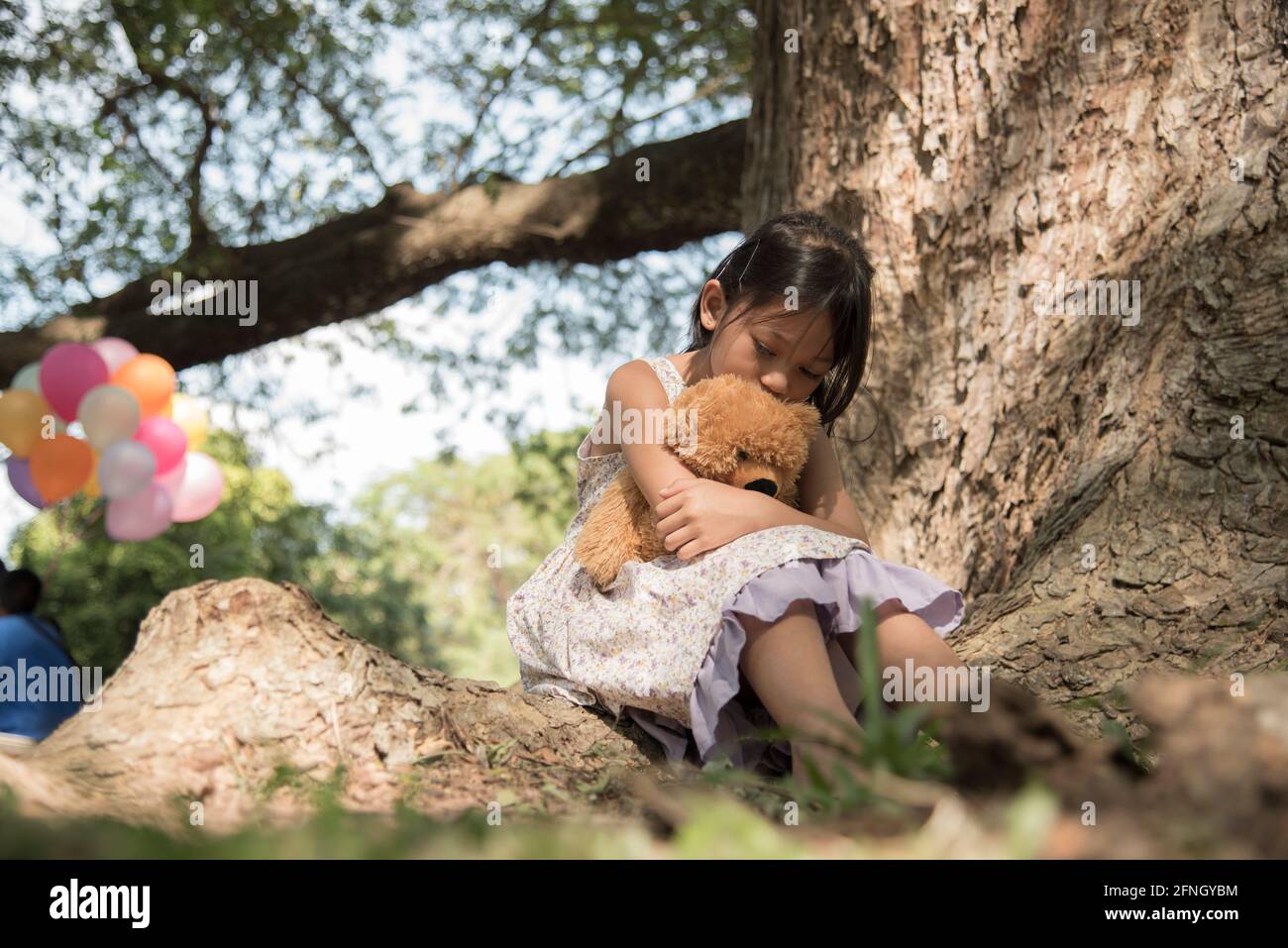 Sad girl feeling alone in the park. Lonely concepts. Beautiful toddler girl  and fluffy stay alone under the big tree Stock Photo - Alamy, image size:1300x957