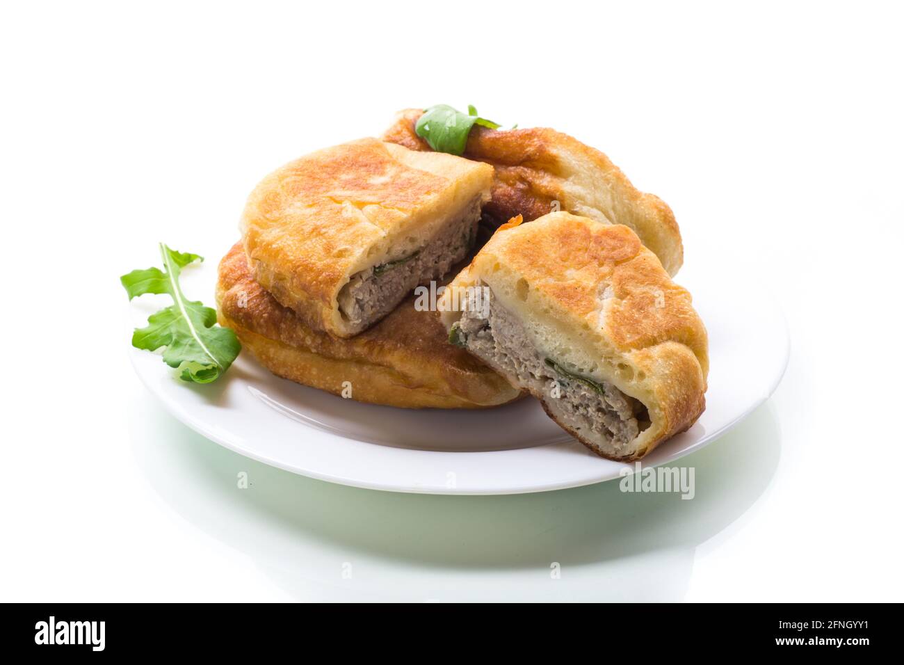 fried pies with meat in a plate on a white background Stock Photo