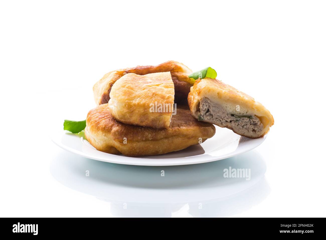 fried pies with meat in a plate on a white background Stock Photo