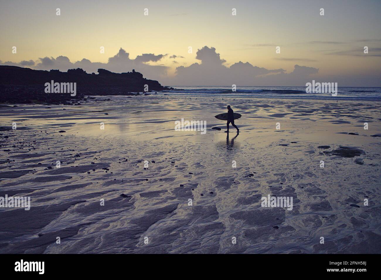 surfer on Porthmeor beach at sunset Stock Photo