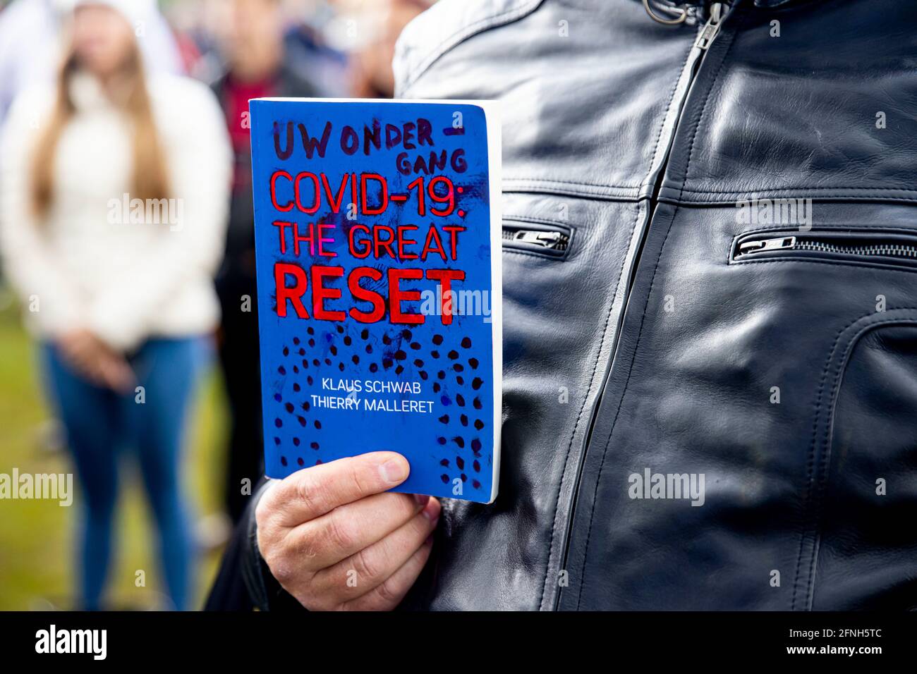 The Hague, The Netherlands. 16th May, 2021. A protester with the book The Great Reset from Klaus Schwab during a protest action on the Malieveld square in The Hague, The Netherlands, 16 May 2021. With his freedom camper Baudet protest against the corona measures. Credit: Patrick van Katwijk//dpa/Alamy Live News Stock Photo