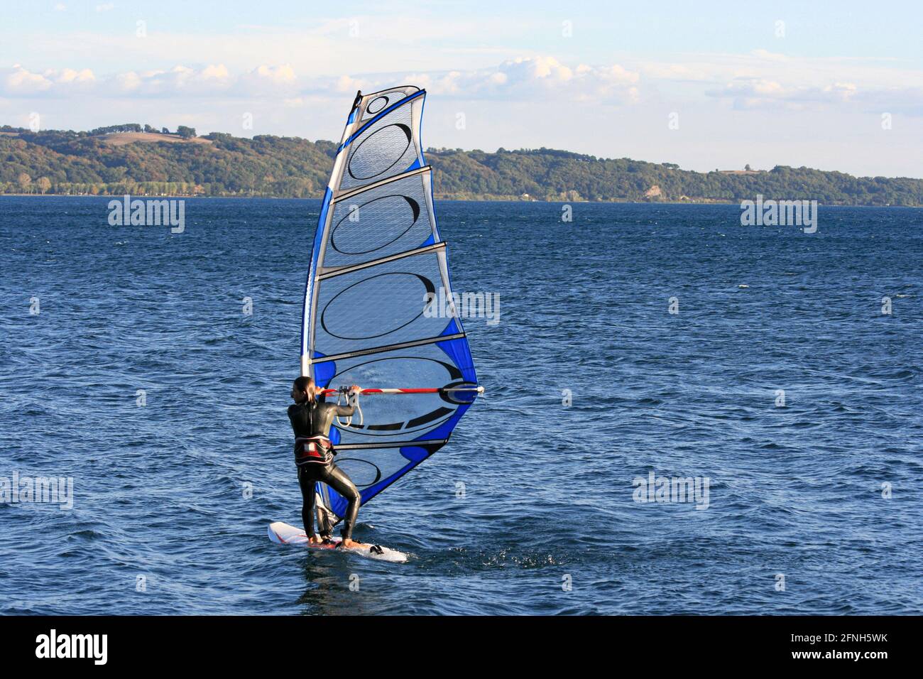 Man windsurfing on a lake in Italy Stock Photo