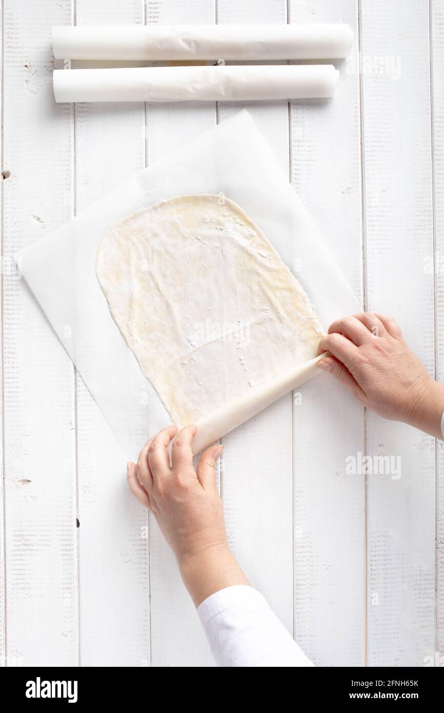 Rolling phyllo dough for apple strudel in a sheet of kitchen paper Stock Photo