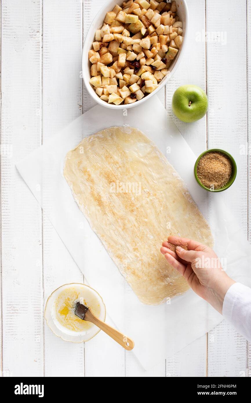 Sprinkle brown sugar on a strudel sheet before adding the filling Stock Photo