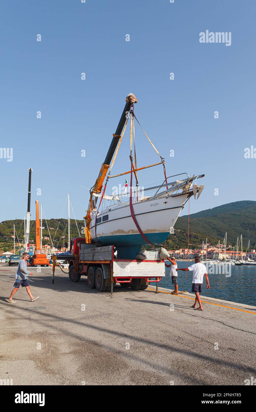 MARCIANA MARINA, ELBA ISLAND, ITALY - JUNE 22, 2012: Team of people preparing to launch a motorboat in the water. Stock Photo