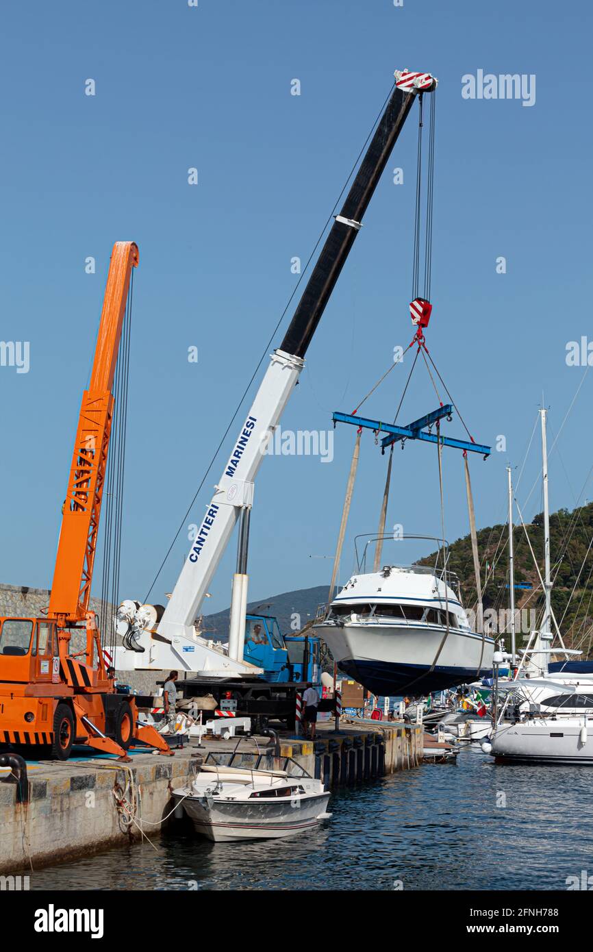 MARCIANA MARINA, ELBA ISLAND, ITALY - JUNE 22, 2012: Boat launch operations with marina crane in the small touristic port. Stock Photo