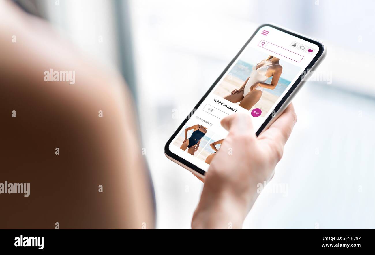 Online shop website in phone. Fashion store product page in smartphone. Woman looking for swimsuit sale. Web site mockup. Stock Photo