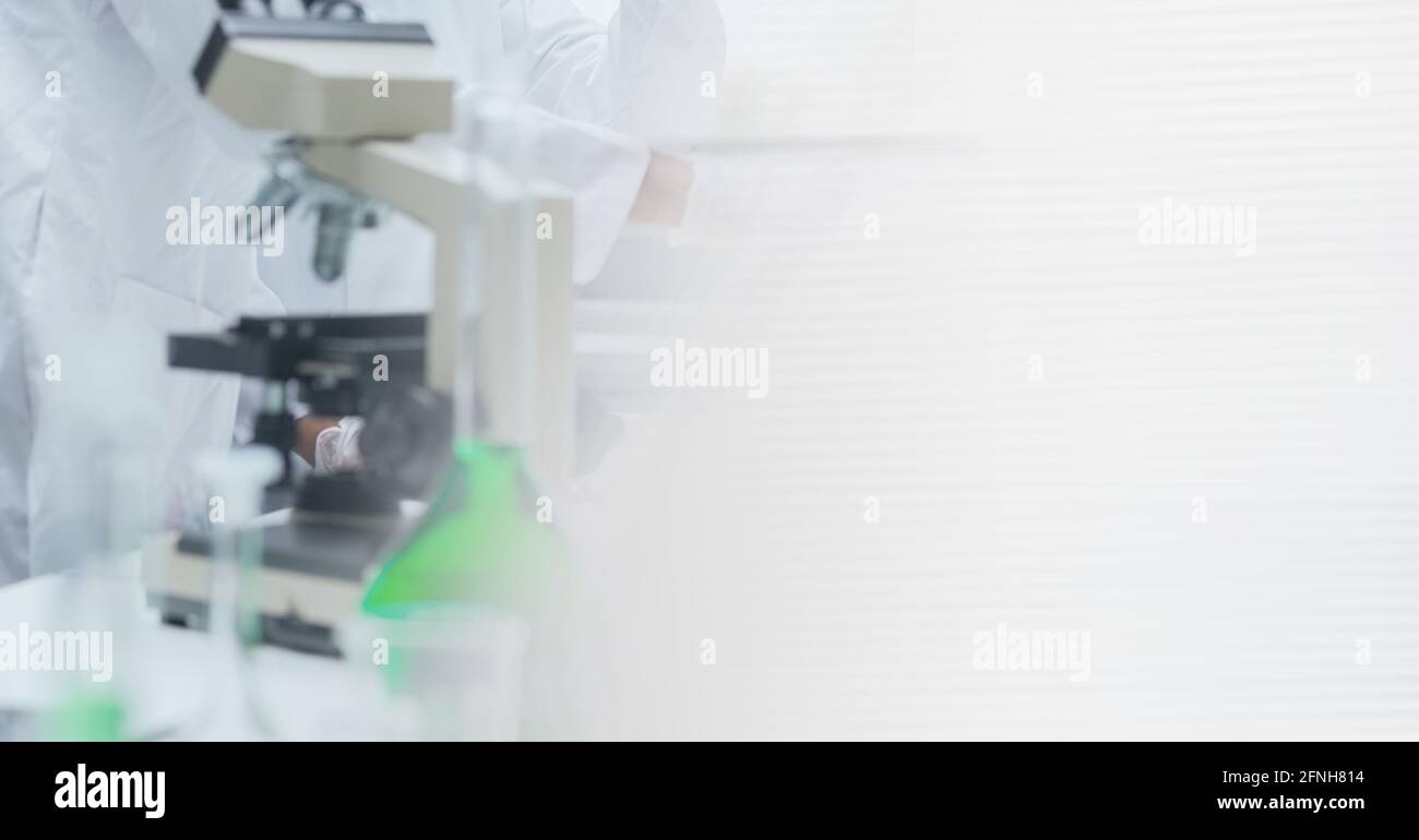 Composition of female scientist in lab using microscope with motion blur Stock Photo