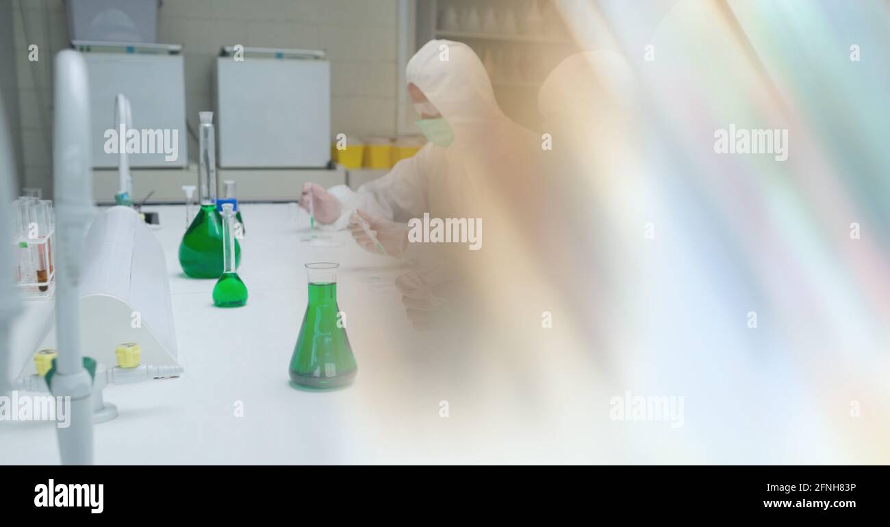 Composition of group of scientists in lab using pipette and test tubes with motion blur Stock Photo