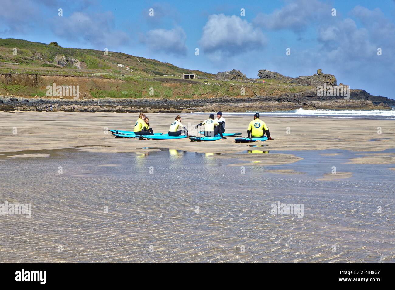 Morning learner surfers sitting discussing their lesson on Porthmeor Beach Cornwall Stock Photo