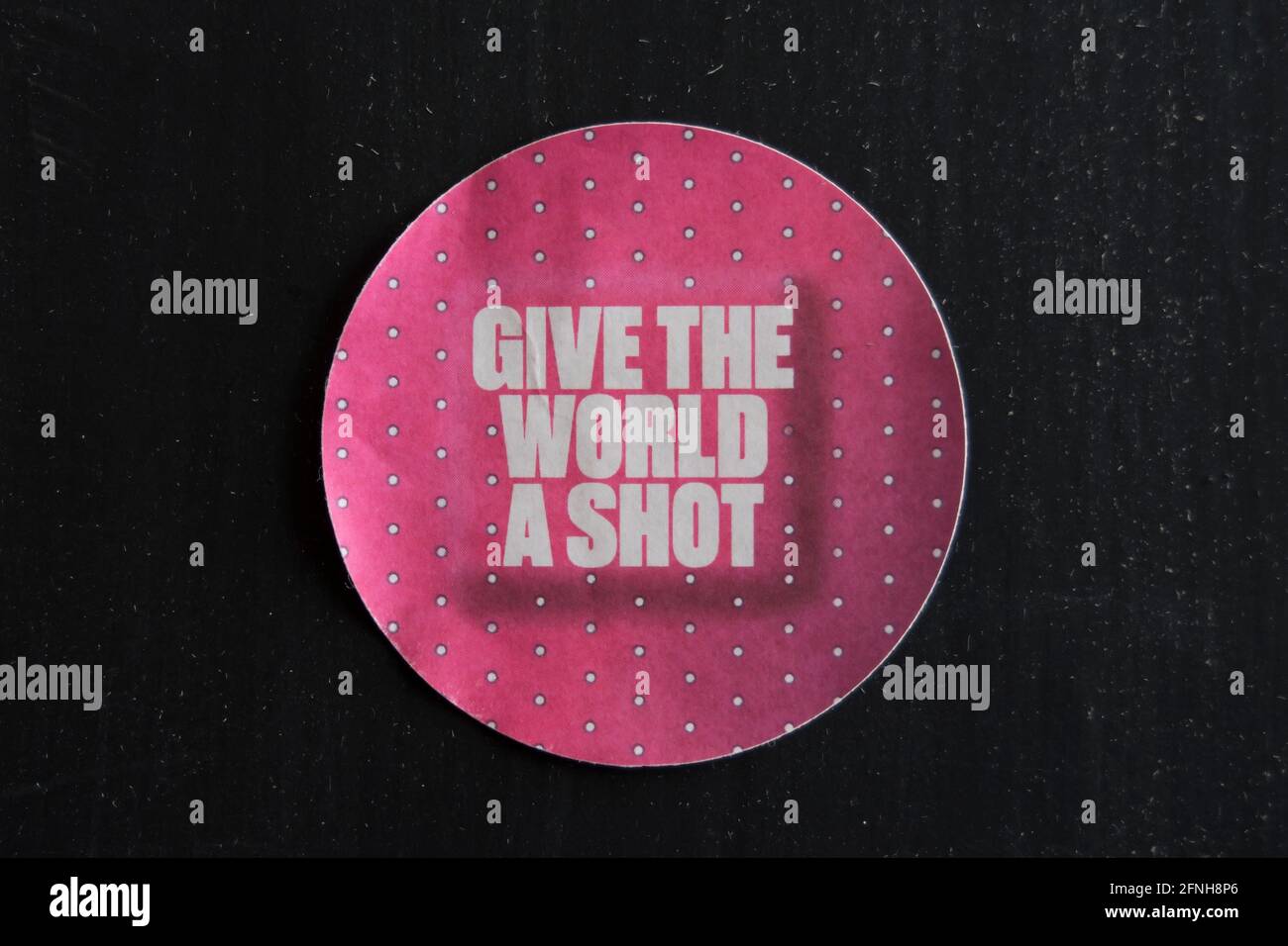 a give the world a shot sticker advocating global rollout of the covid 19 vaccine Stock Photo