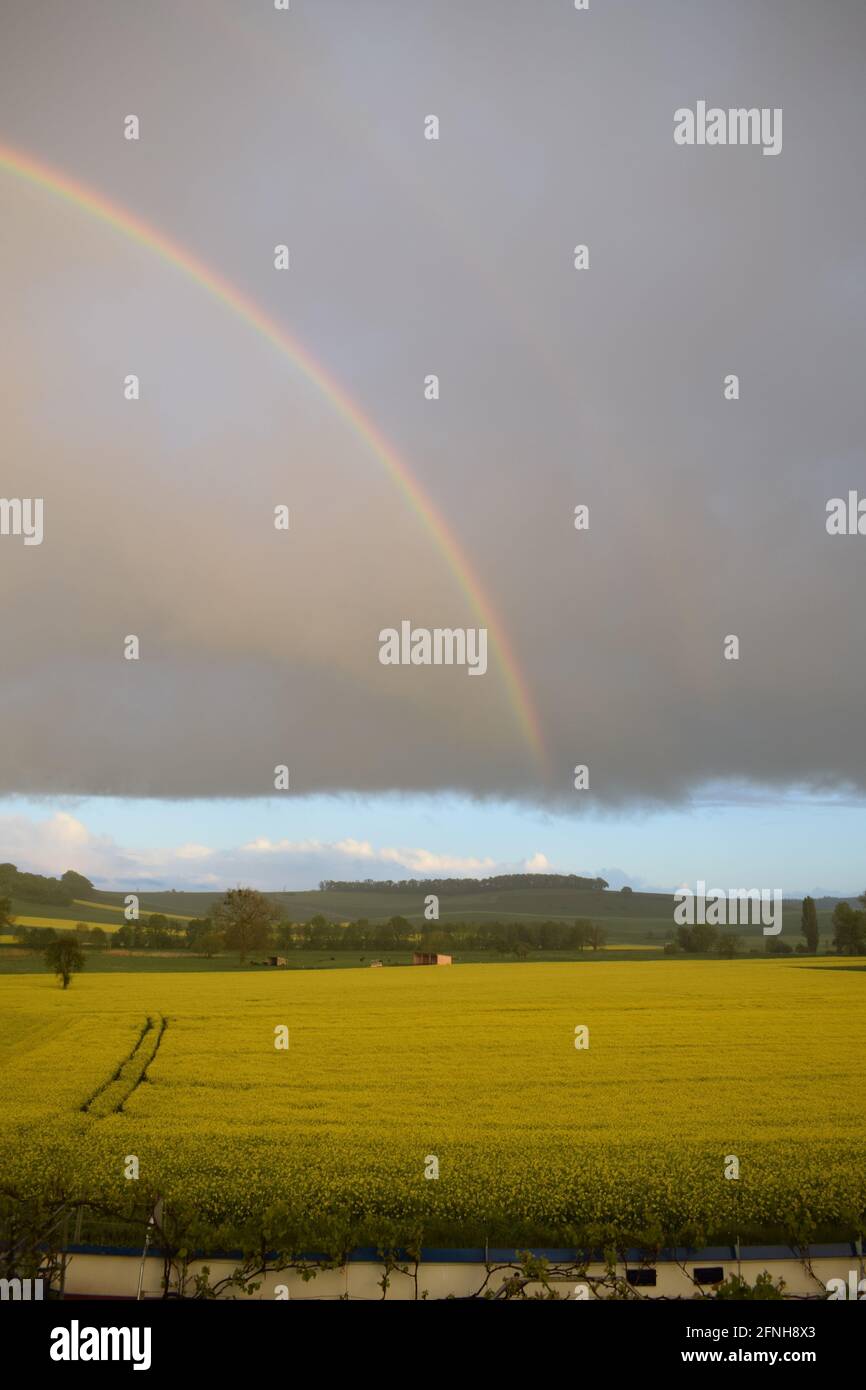 huge rainbow in front of dark clouds Stock Photo