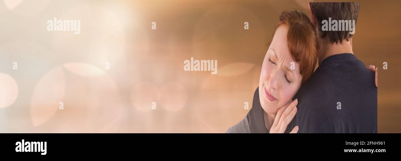 Caucasian couple hugging, woman with eyes closed leaning her head on her partners shoulder Stock Photo