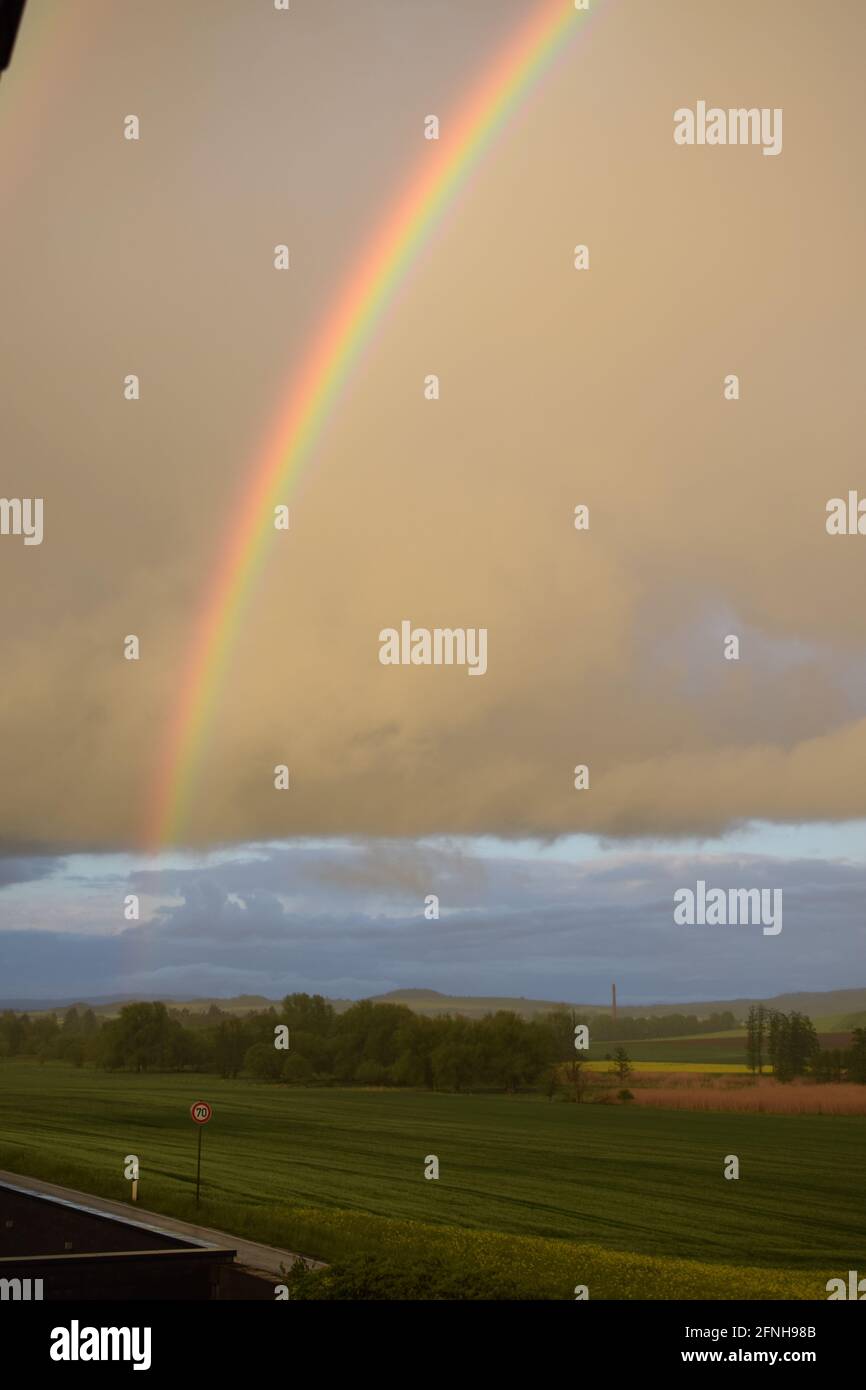huge rainbow in front of dark clouds Stock Photo