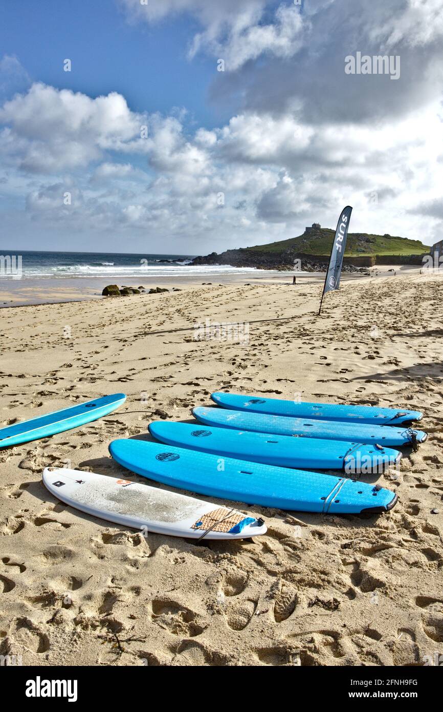 turquoise surf boards lined up on Porthmeor beach Cornwall Stock Photo