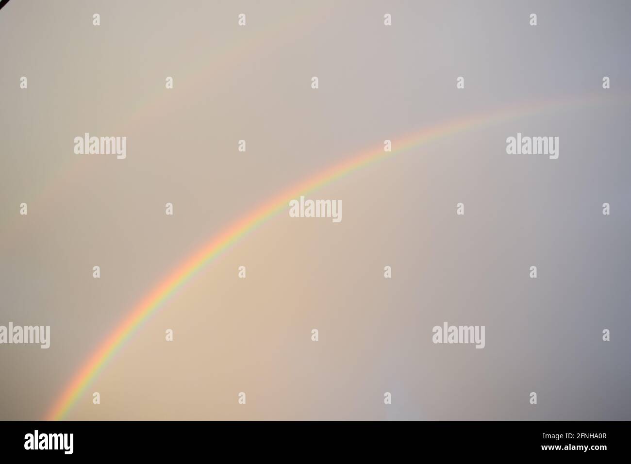 huge rainbow in front of dark clouds Stock Photo