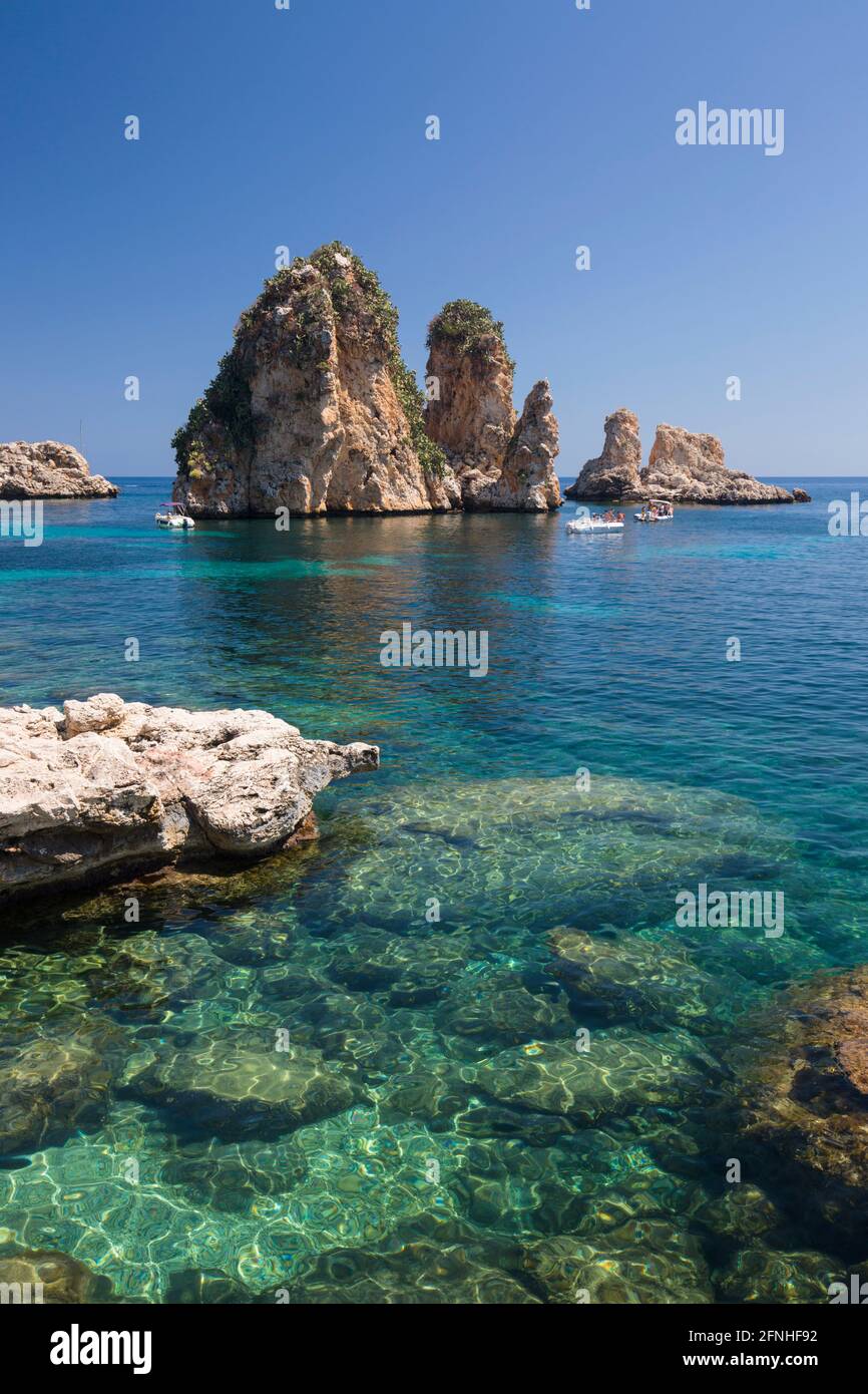 Scopello, Trapani, Sicily, Italy. View over rocky cove to the Faraglioni, a series of stacks in the Gulf of Castellammare off the Tonnara di Scopello. Stock Photo