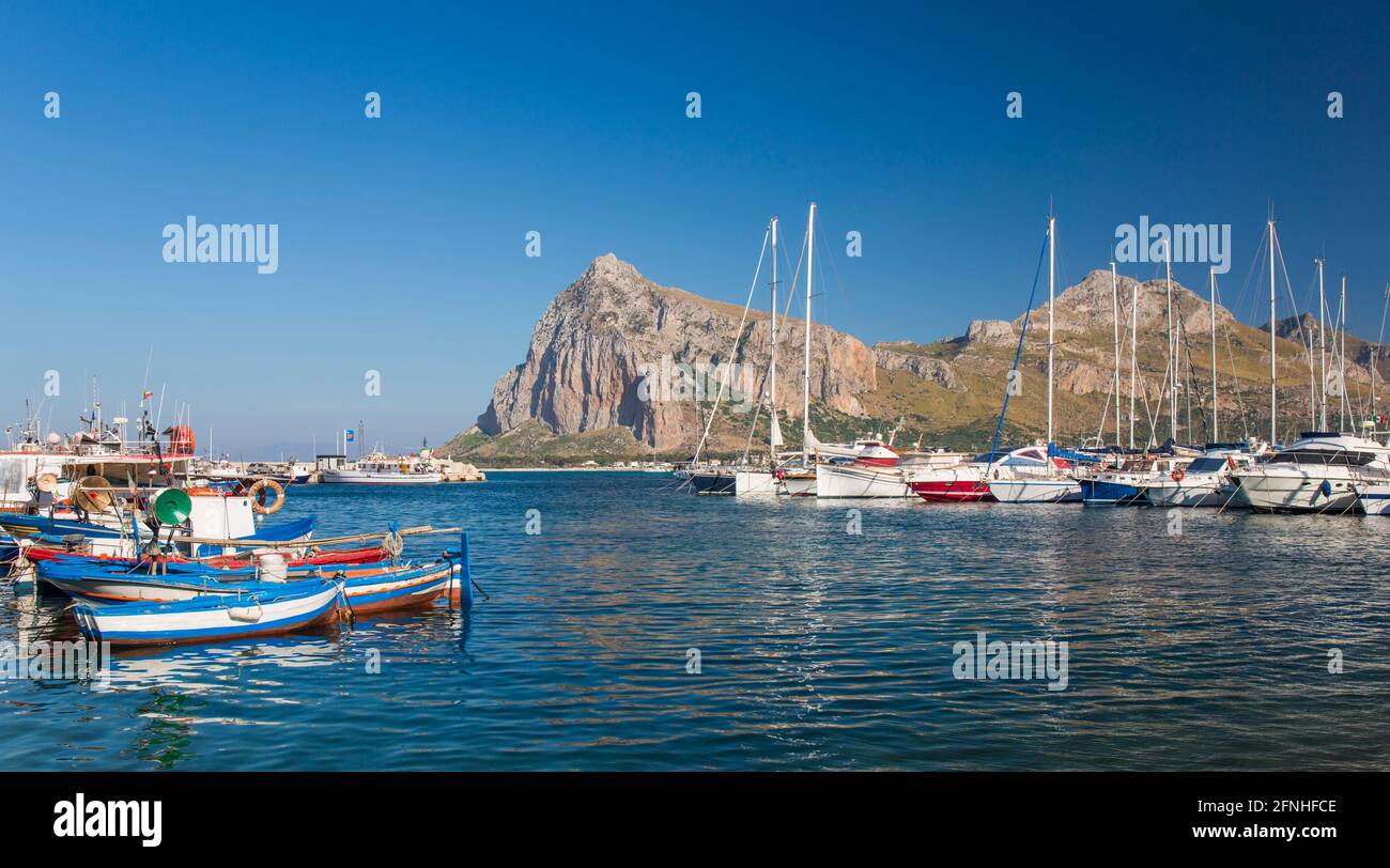 San Vito Lo Capo, Trapani, Sicily, Italy. Panoramic view across colourful harbour to the towering peaks of Monte Monaco and Pizzo di Sella. Stock Photo