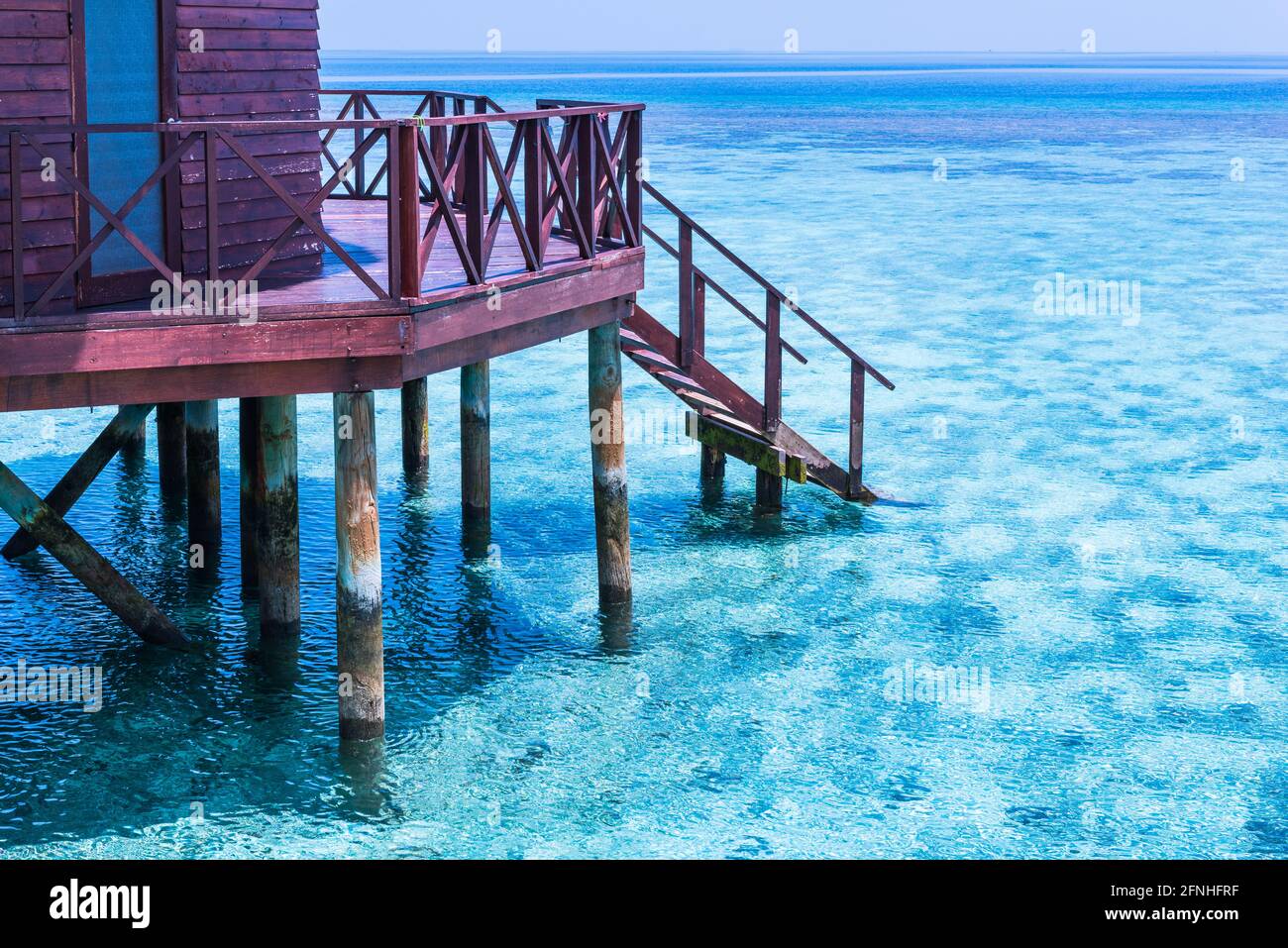 Part of the water bungalow. Stairs down to the ocean. Rest on the sea. The output of absolute relaxation. Maldives. Tropical island resort. Stock Photo