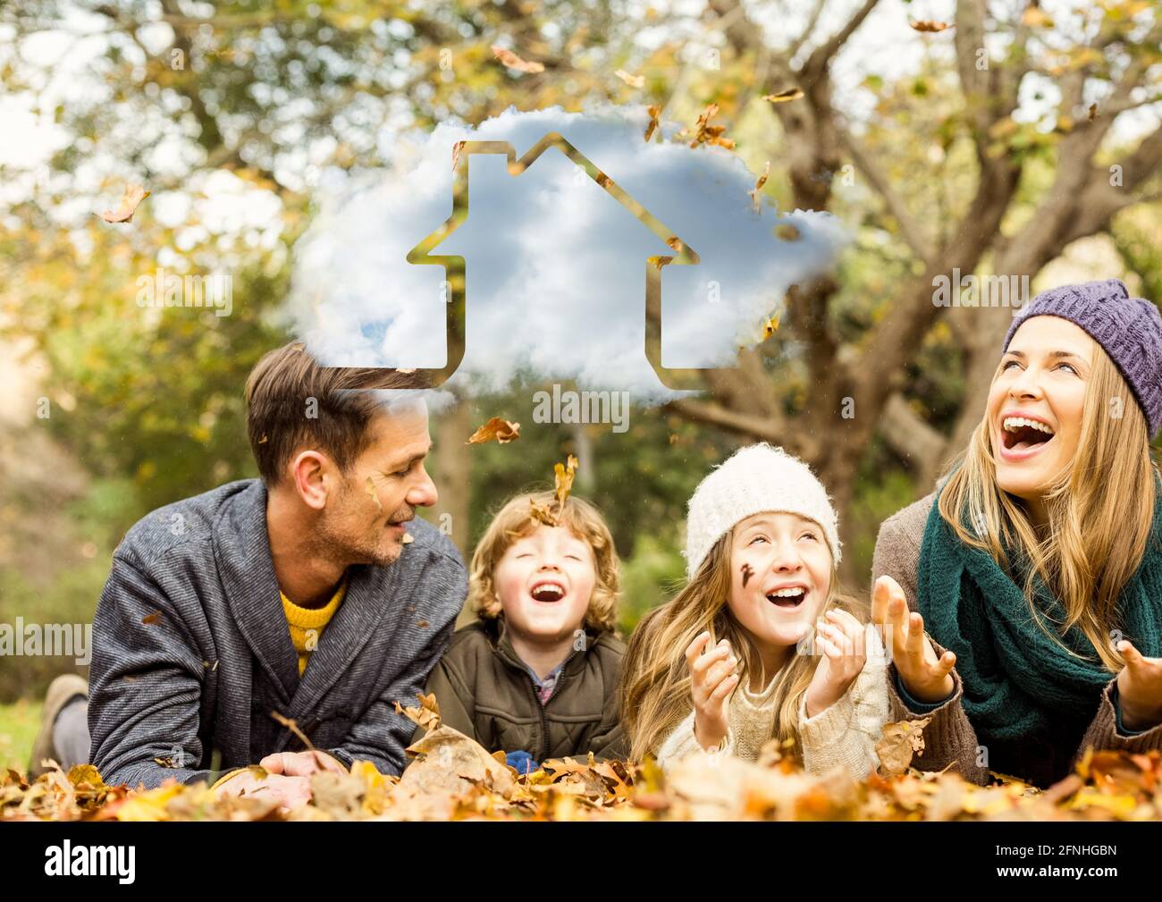 Composition of cloud with house icon over happy caucasian family in autumn park Stock Photo