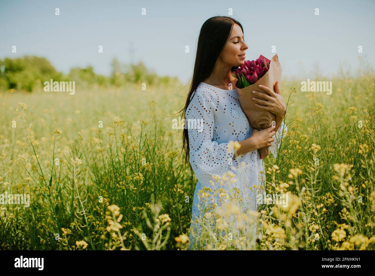 Pretty young woman in the rapeseed field Stock Photo - Alamy