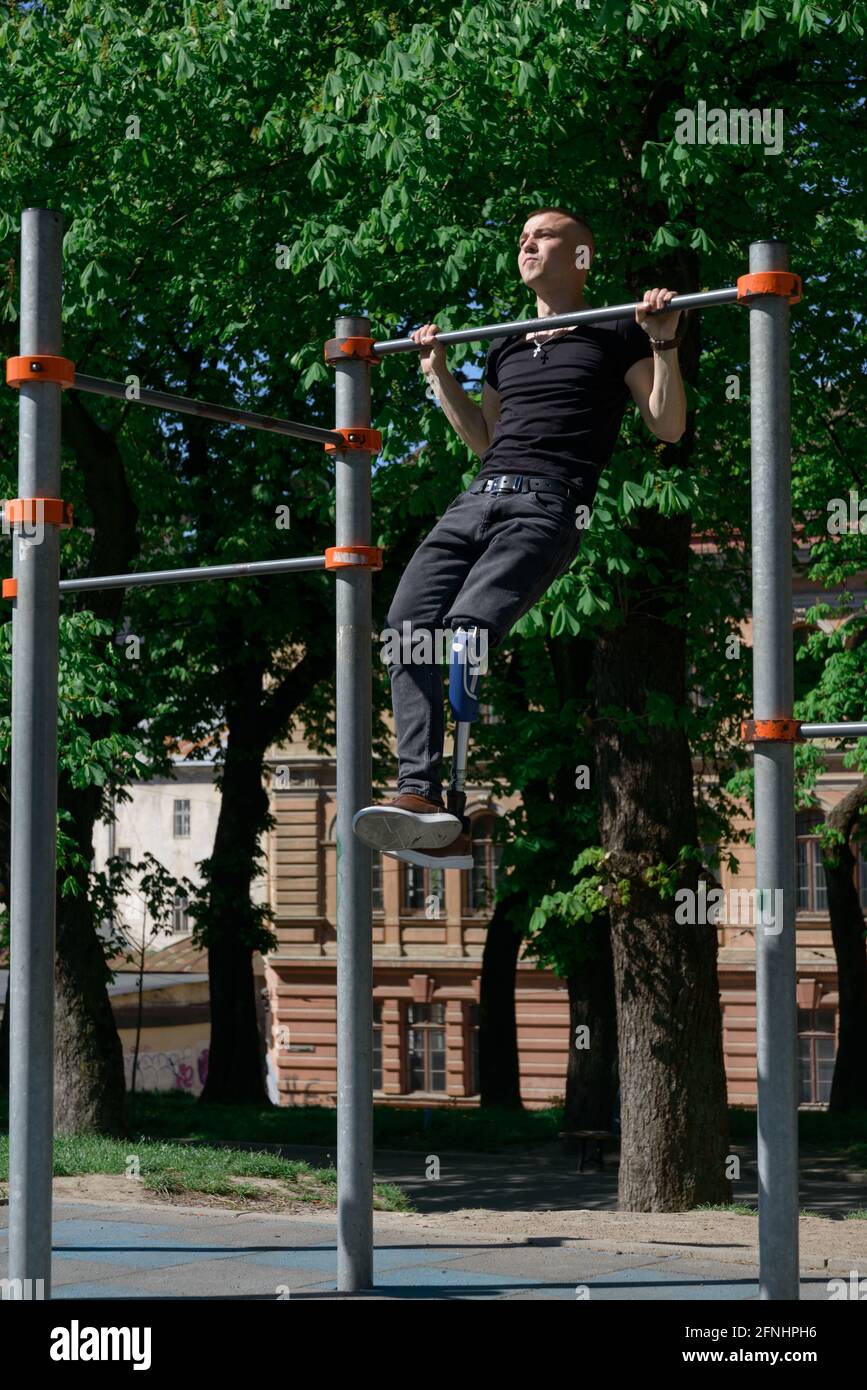 athletic young man with artificial leg working out on a bars Stock Photo