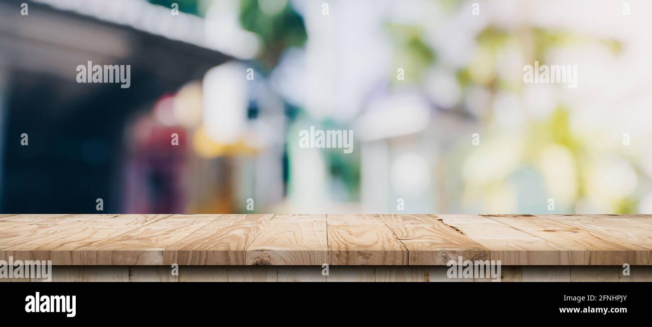 Empty wood table and blurred light table in coffee shop and cafe with ...
