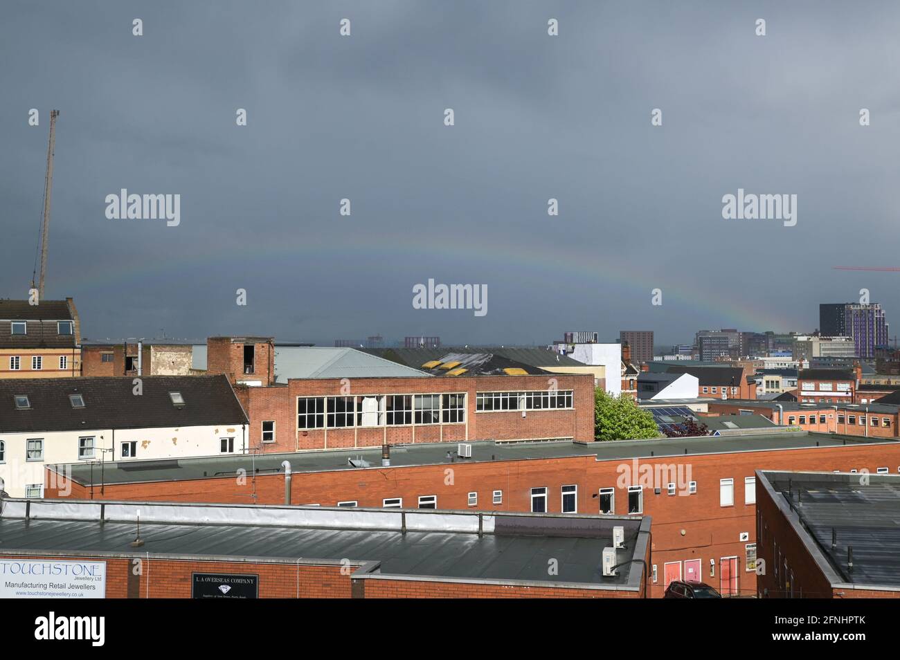 Aston, Birmingham, West Midlands, UK. 17th May 2021. A rare low rainbow formed over the Aston area of Birmingham city centre, England this afternoon as heavy rain hit many parts of the country. The bow was unusually low and started from the faculty building at the right of the image. Pic by Sam Holiday/Alamy Live News Stock Photo