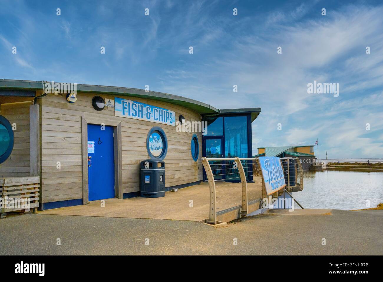 Stylish wood cladded Fish and Chip shop on the promenade at St Anne's, Lancashire, UK under a bright blue sky Stock Photo