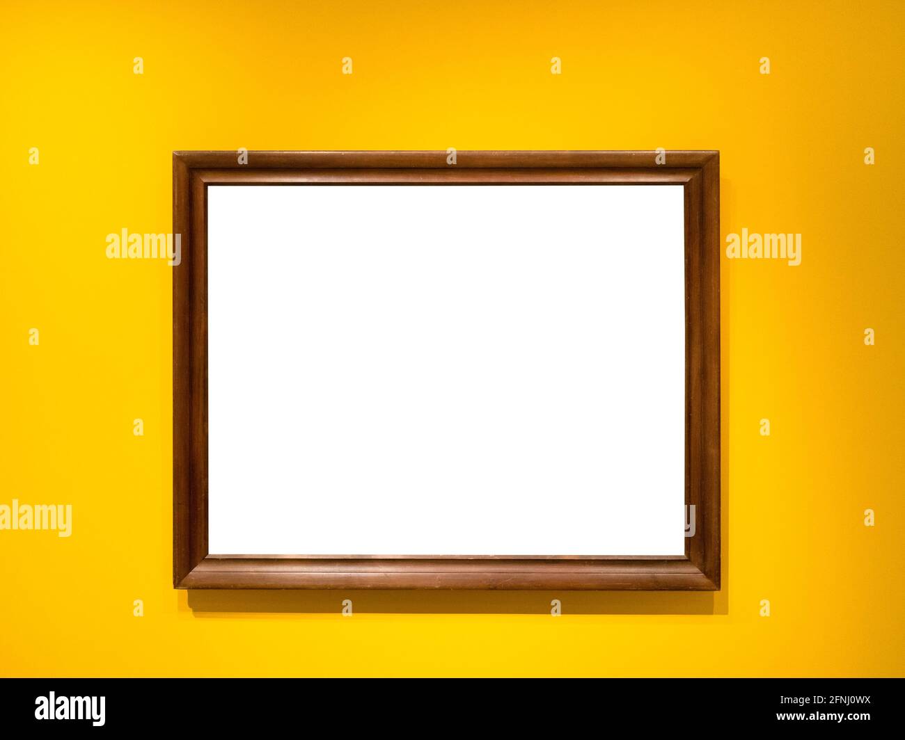 natural brown wooden picture frame with cutout canvas on horizontal yellow wall Stock Photo