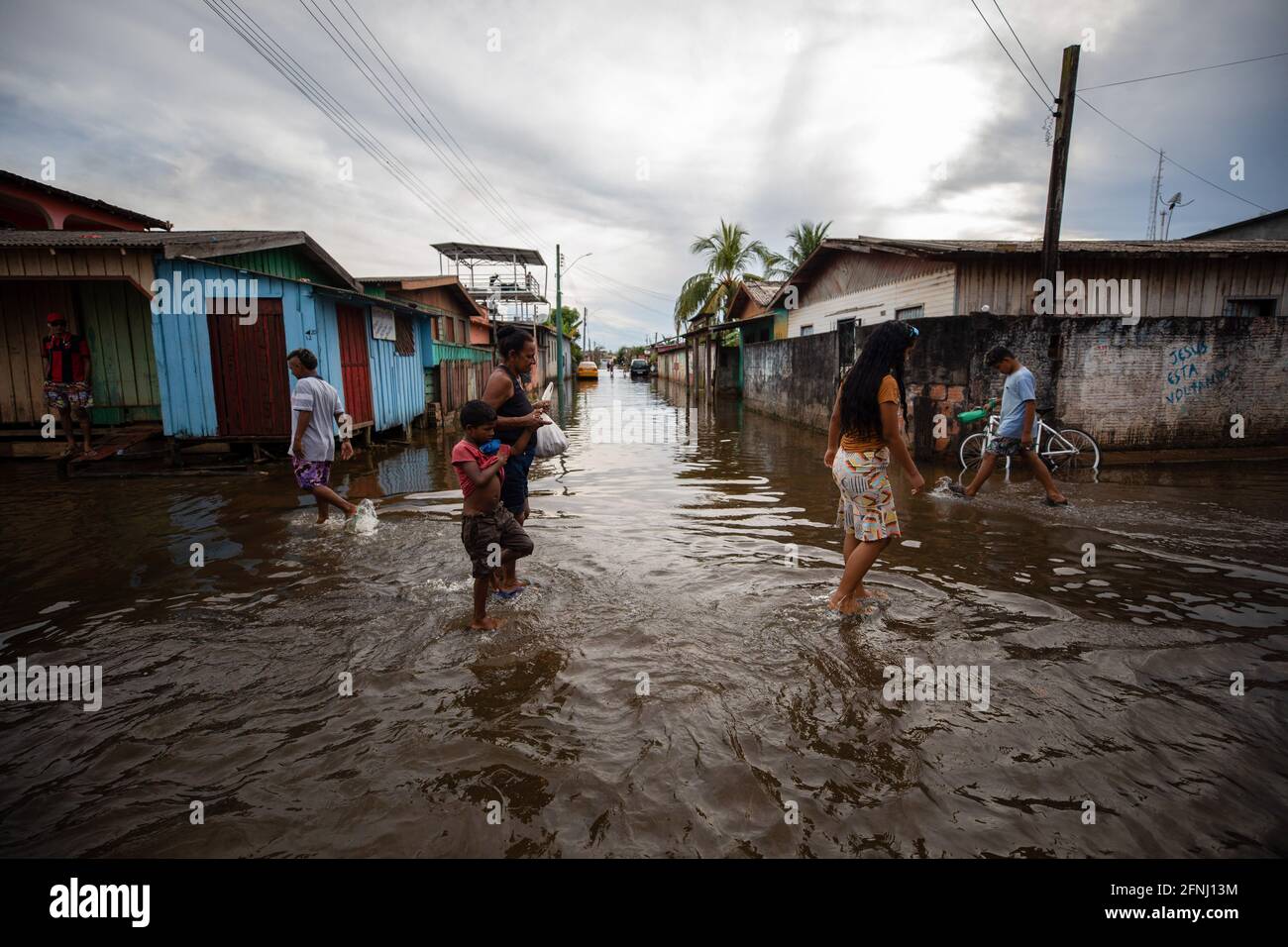 Iranduda, Brazil. 14th May, 2021. People walk through a flooded street