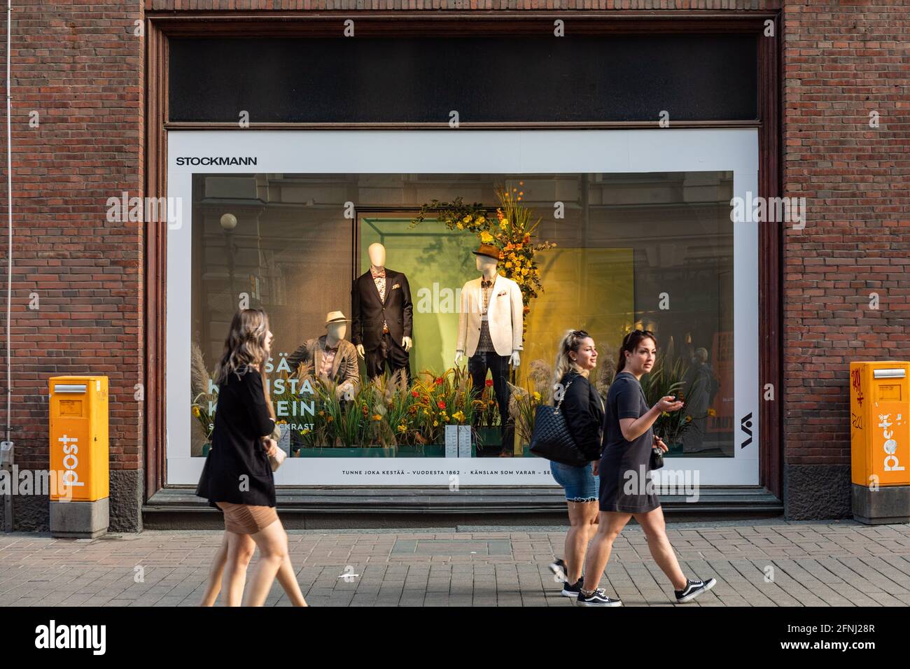 People passing Stockmann department store window displaying summer clothes in Helsinki, Finland Stock Photo
