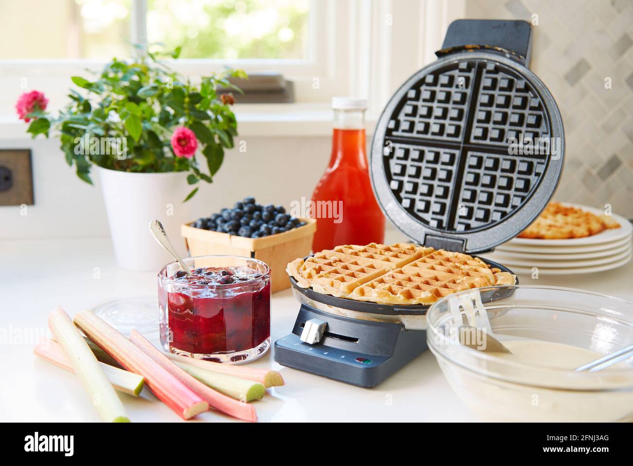 Rhubarb blueberry breakfast sauce with waffle in waffle iron Stock Photo