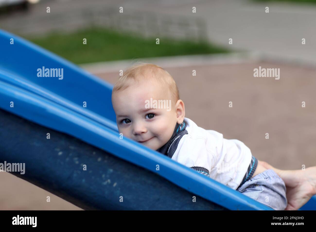 Child is climbing up a slide at playground Stock Photo Alamy