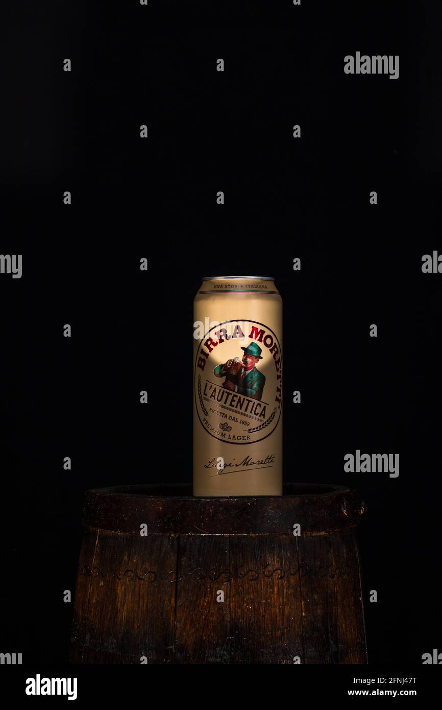 Can of Birra Moretti beer on wooden barrel with dark background