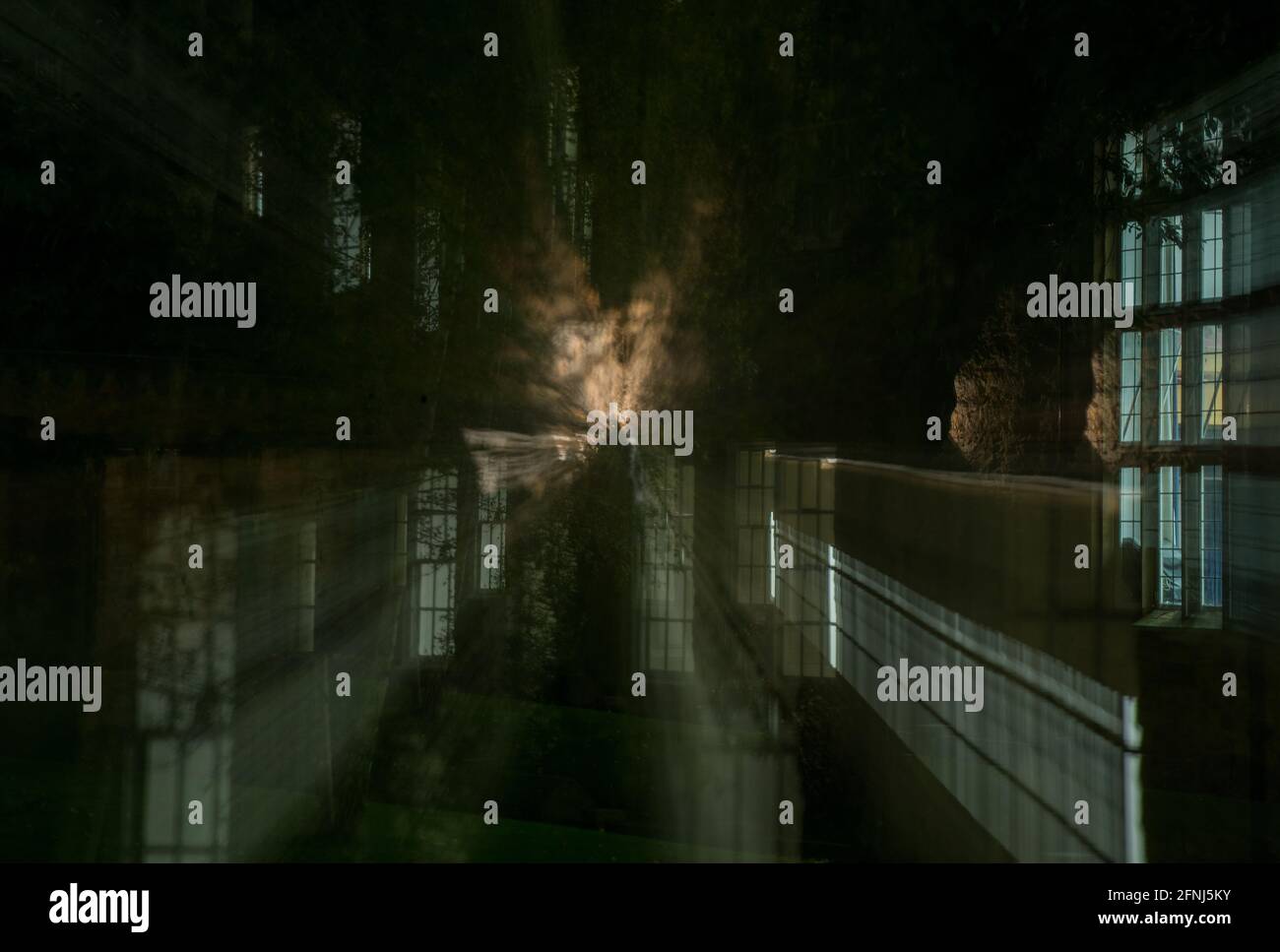 An ephemeral and ghostly type image with strange clouds emanating from among lighted windows of buildings at night Stock Photo