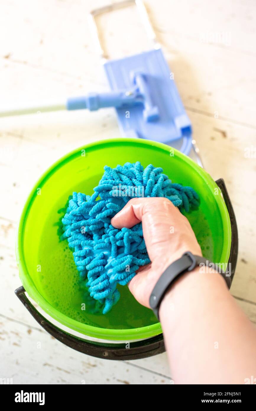 Washing a doormat in a bucket of water. Room cleaning Stock Photo Alamy
