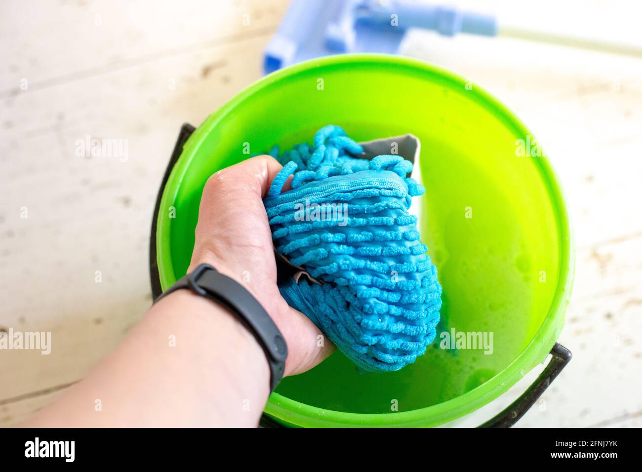 Washing a doormat in a bucket of water. Room cleaning Stock Photo Alamy