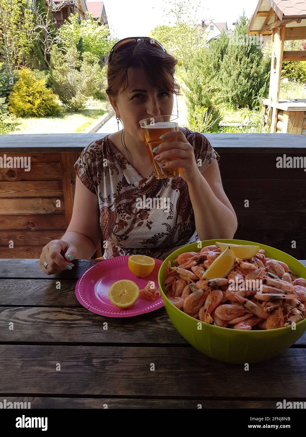 Woman eating shrimp and drinking beer Stock Photo Alamy