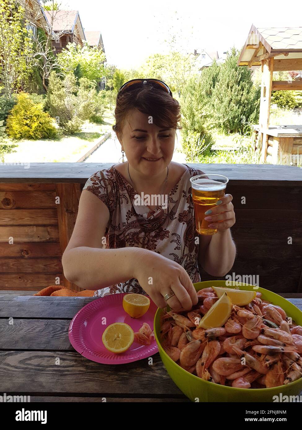 Woman eating shrimp and drinking beer Stock Photo Alamy