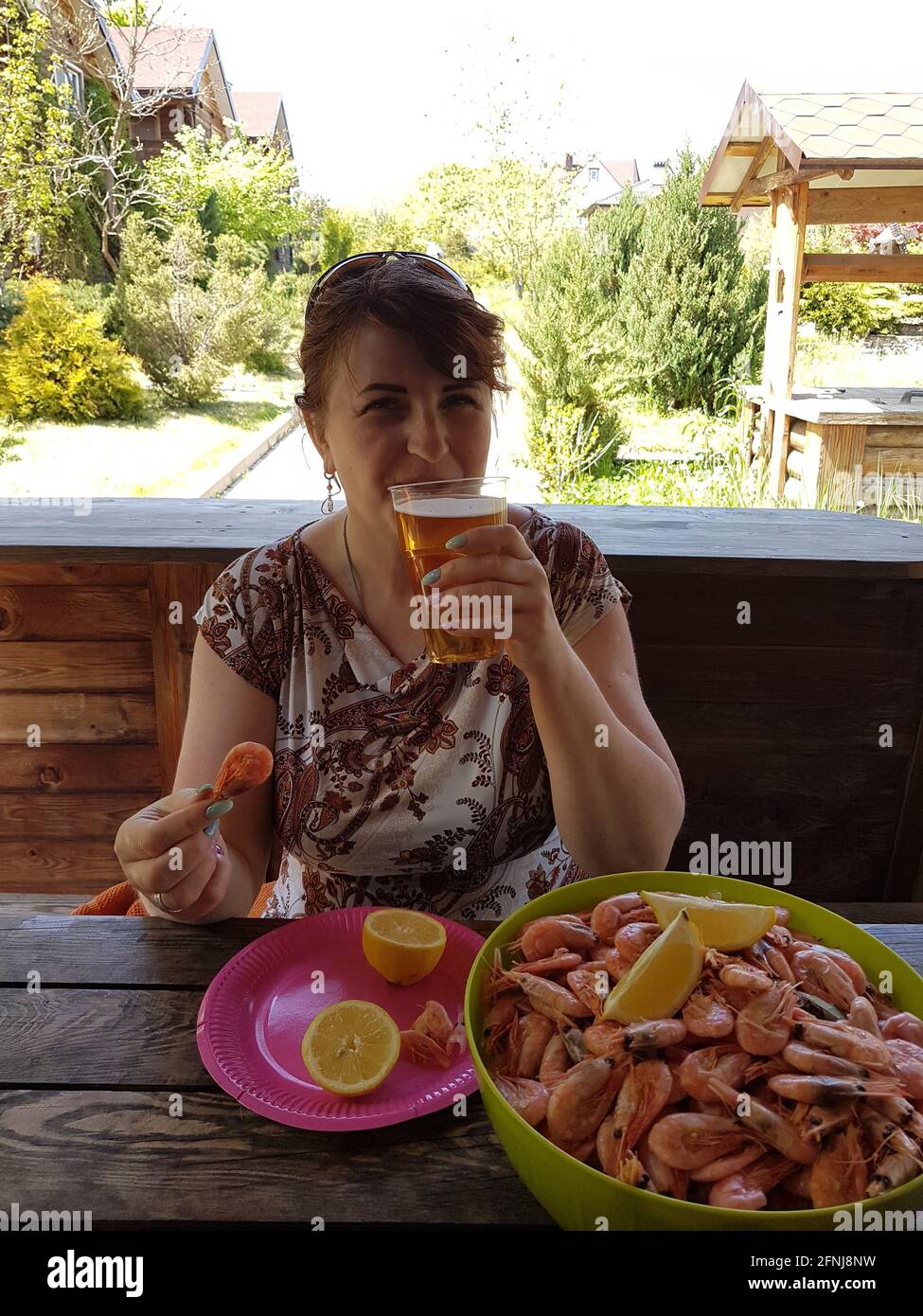 Woman eating shrimp and drinking beer Stock Photo Alamy