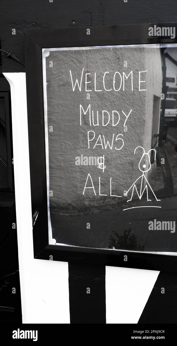 Welcome muddy paws and all sign outside the Queen Head pub in Hawkshead, Cumbria, England, UK. Stock Photo