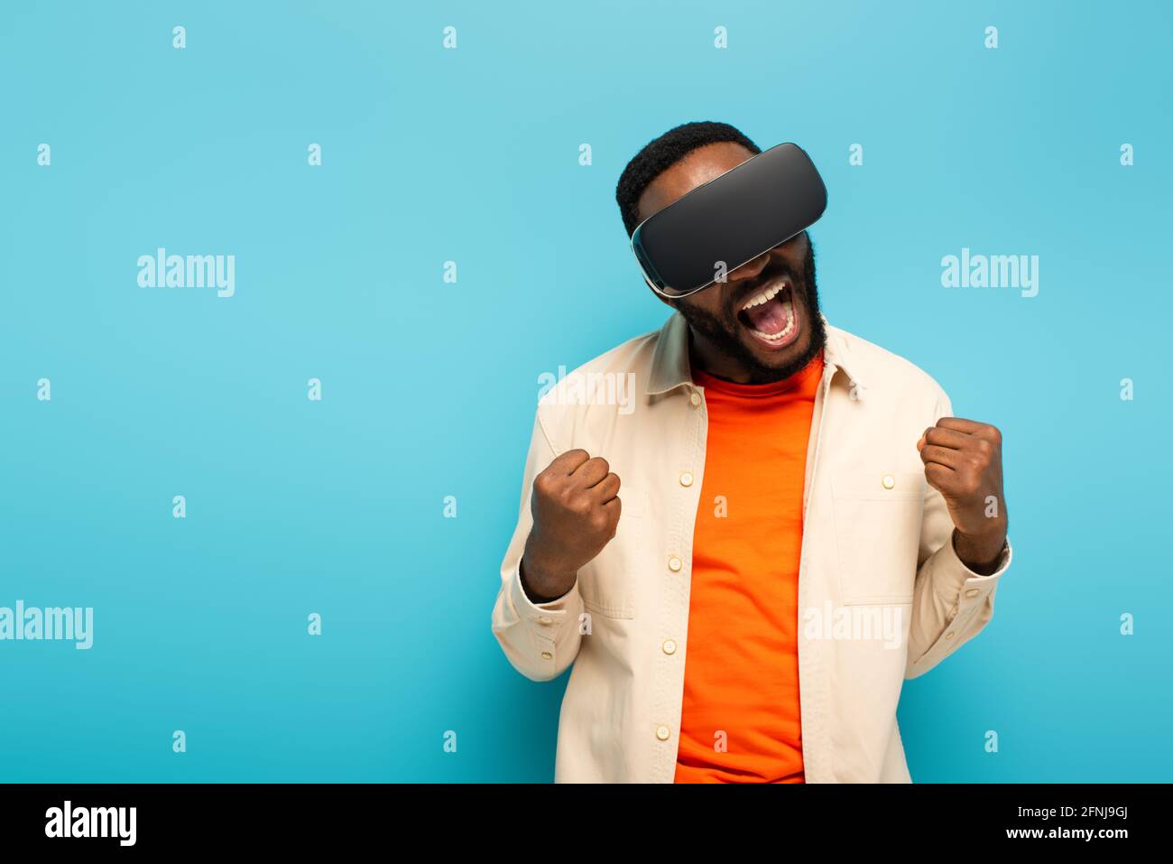 excited african american man in vr headset showing rejoice gesture ...