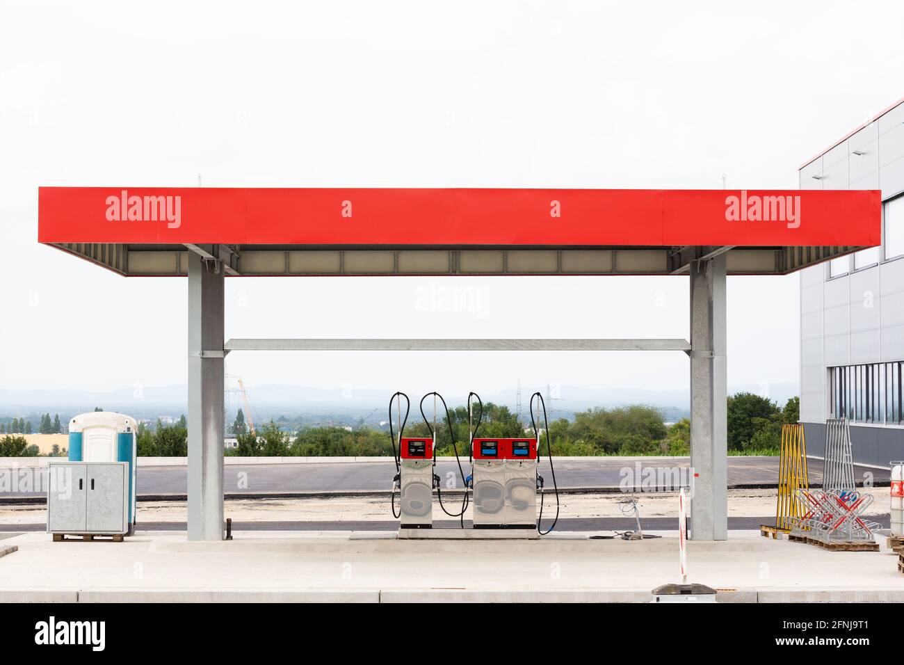 Gas station with two petrol pumps under construction on a hill and a view of a valley and the sky. Stock Photo