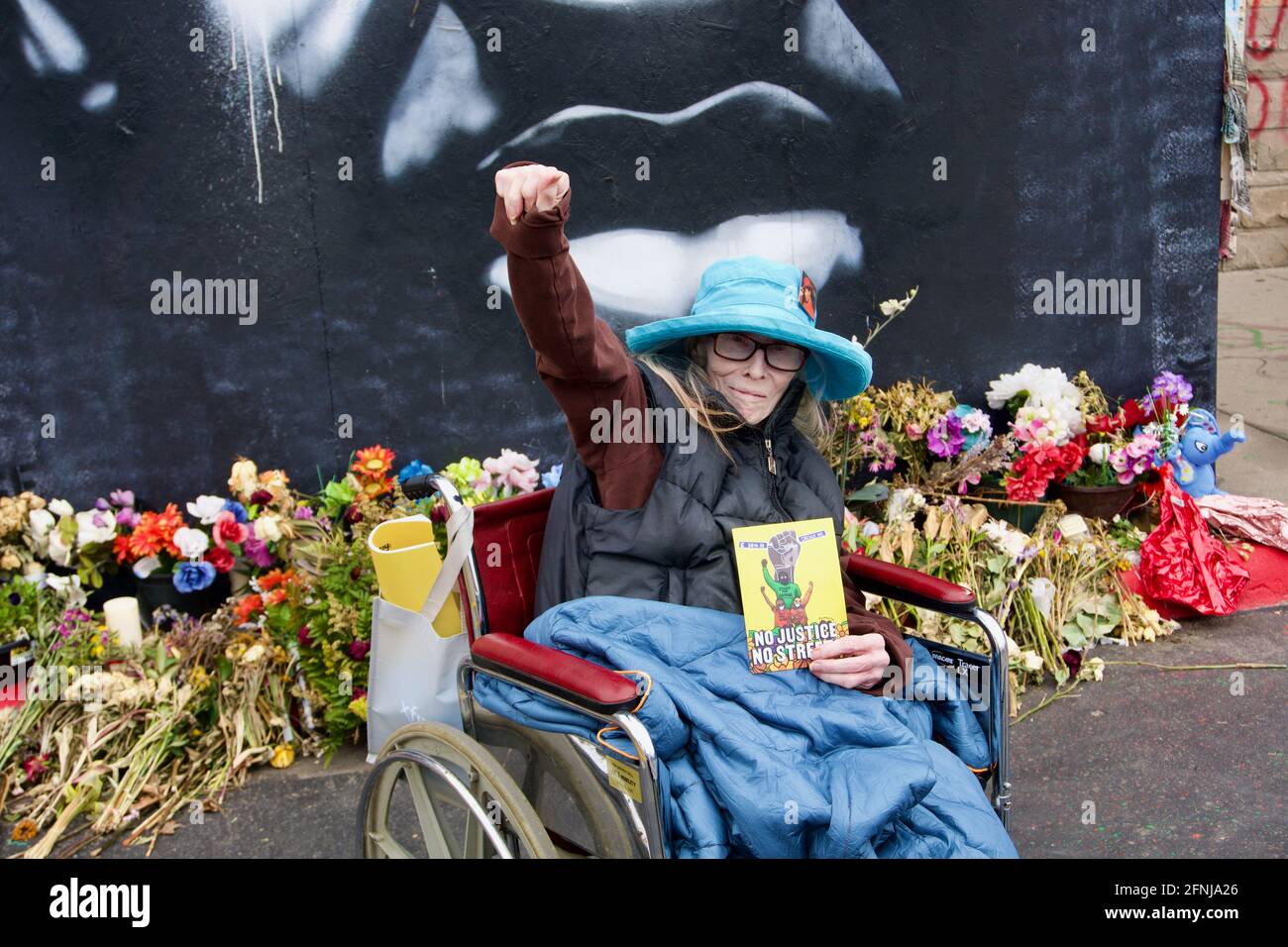 Cancer patient Karen Cato holds her fist up at the George Floyd memorial site at 38th & Chicago. George Floyd Square. Minneapolis, Minnesota Stock Photo